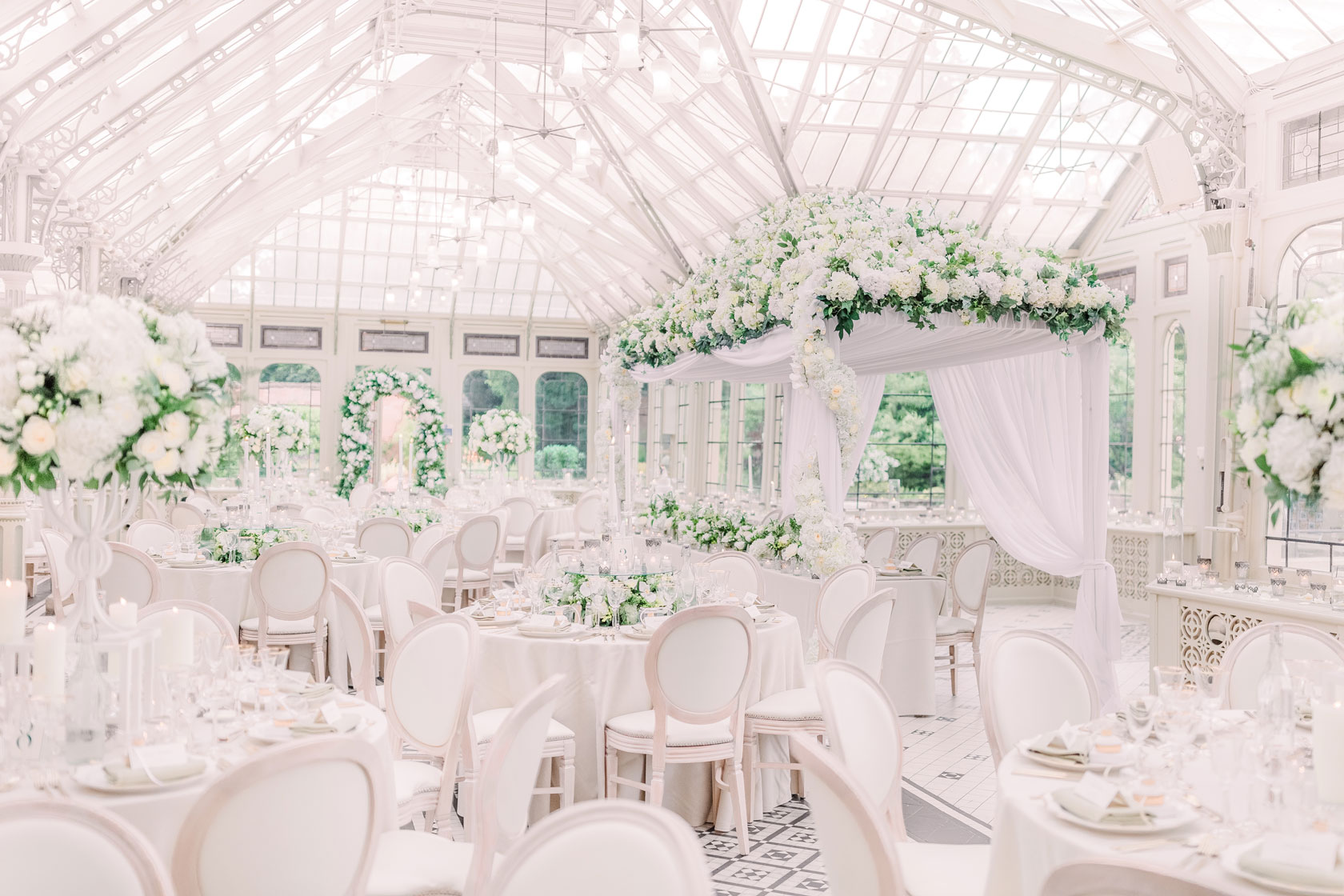 A stunning white flowerhouse inside a glass house orangery at Kilworth House