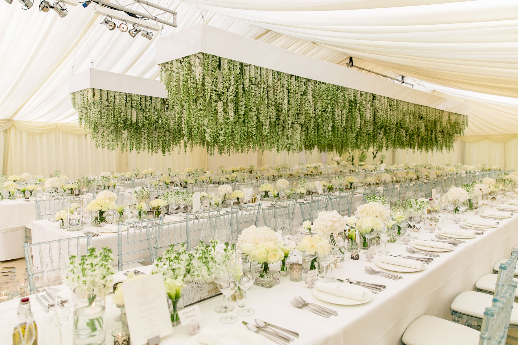 A marquee wedding with thousands of delphiniums hanging above the tables
