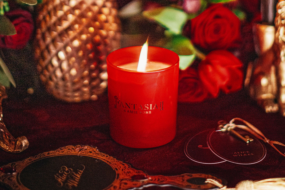a red candle with gold logo