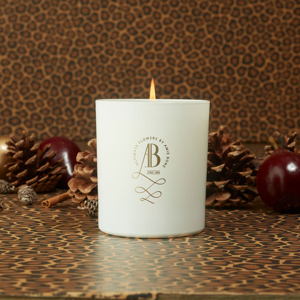 a white candle with gold writing