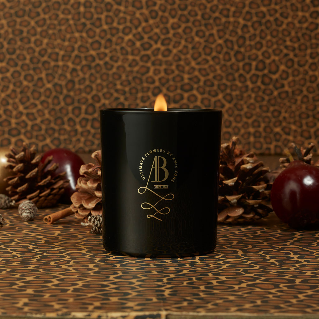 a black candle with gold writing