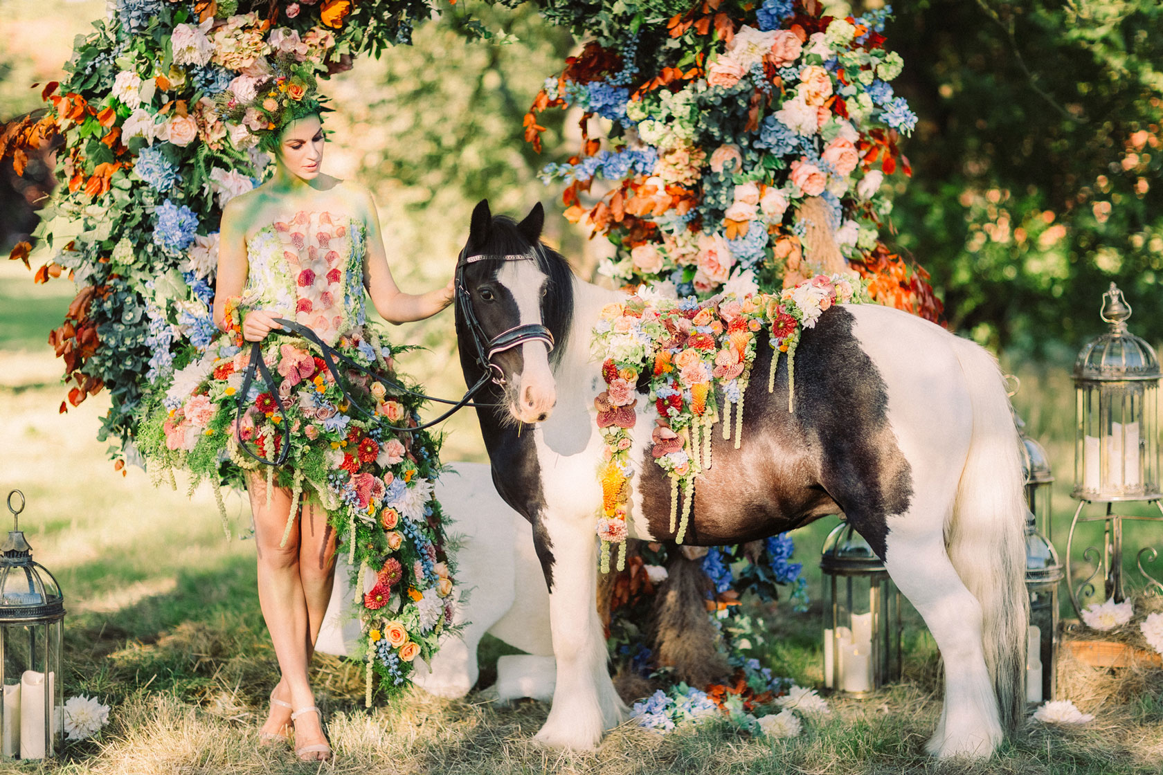 a horse and woman dressed in summer flowers