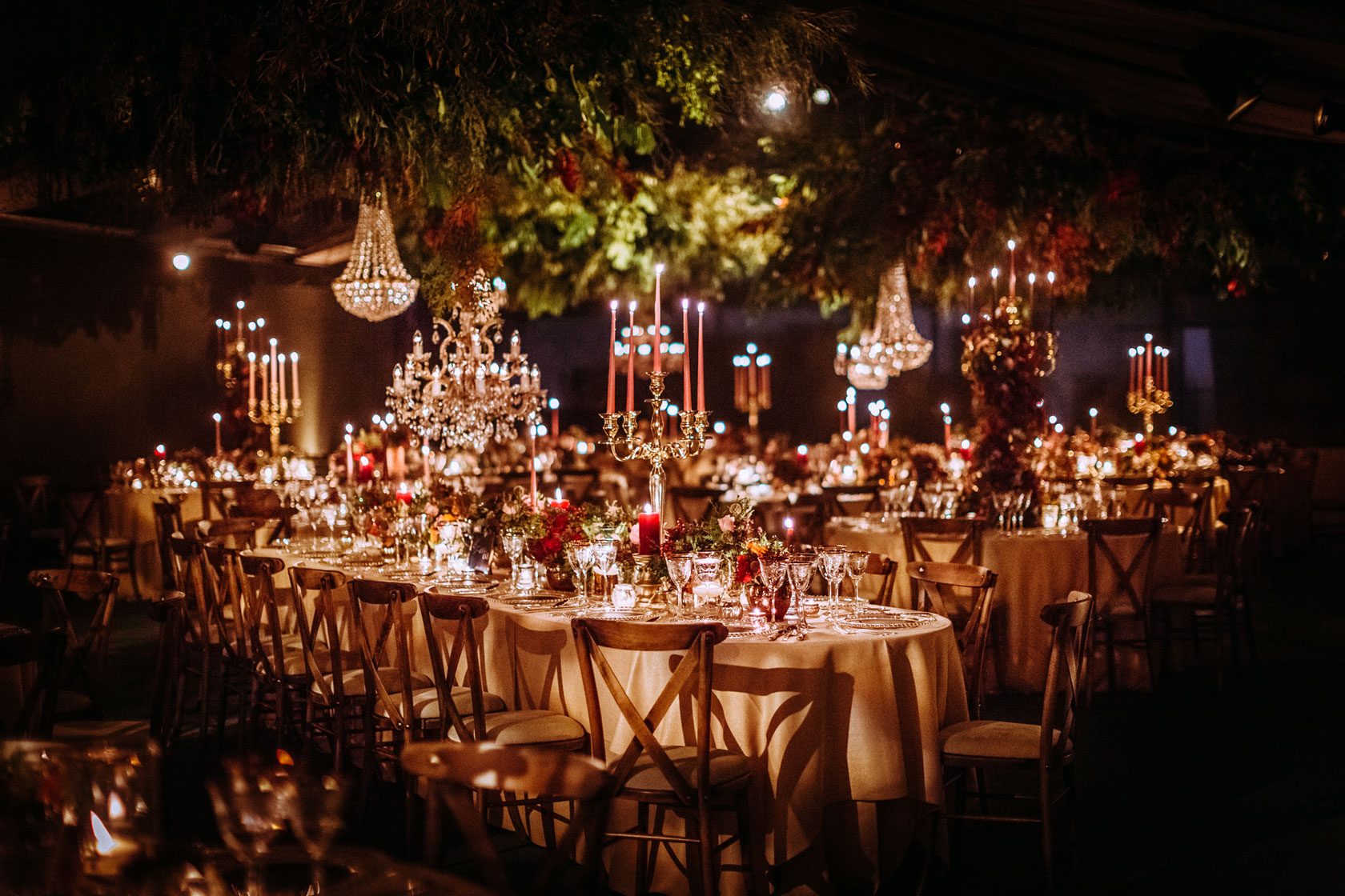a candlelit wedding in a marquee with hanging florals